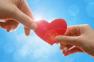 A couple's hand holding heart