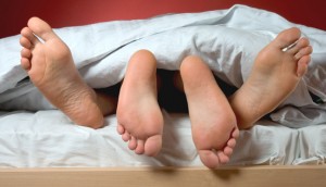A couple's feet on bed